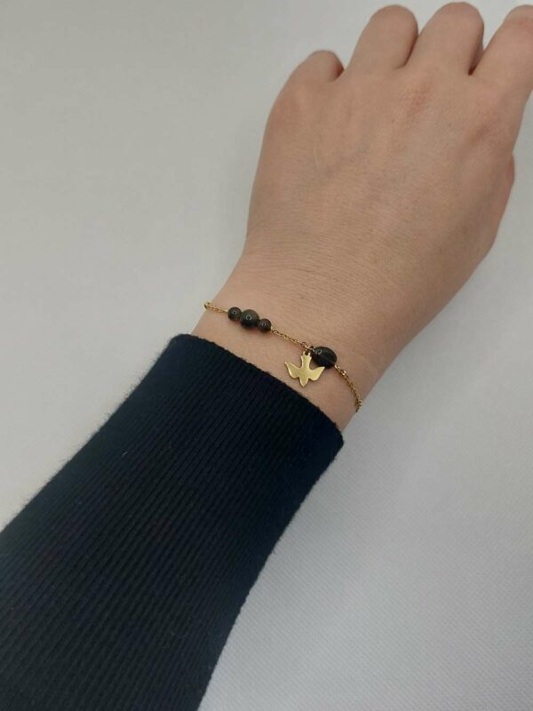 bracelet avec plusieurs pierre d'obsidienne et un médaillon oiseau